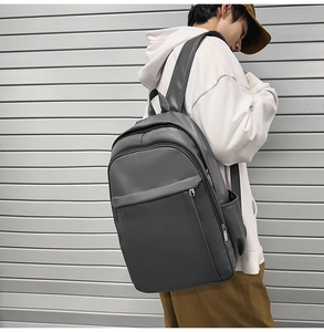 Side view of dark gray matte PU leather backpack on male model for urban commuting style