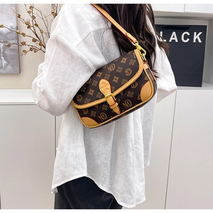 Detail of vintage monogram crossbody bag featuring a metal buckle and high-quality leather