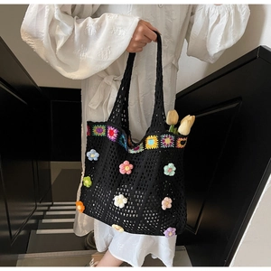 Dettaglio borsa tote nera all'uncinetto con fiori 3D colorati e tracolla con motivi