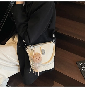 Détail du sac seau blanc cassé en cuir avec fermoir argenté et breloque ours peluche