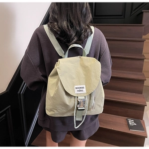 Detail of light green nylon backpack with metal buckle and waswac rules woven label