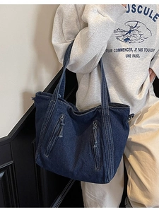 Minimalist deep blue denim tote bag with functional zippers and stylish tassel details
