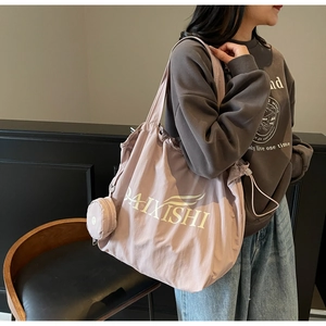 Detail der altrosa Nylon-Tragetasche mit kleinem Beutel, getragen als Schultertasche