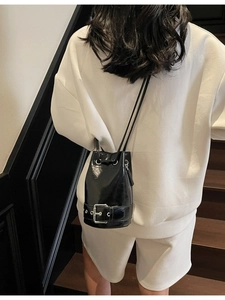 Sac seau minimaliste en cuir verni noir avec boucle en métal argenté et cordon