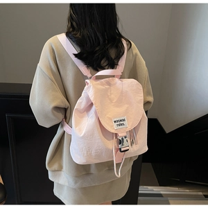 Rear view of a pink casual canvas backpack featuring a silver buckle and woven label detail