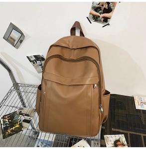 Detail of dark brown leather backpack showing smooth PU texture and large front zipper pocket