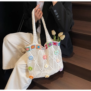 Dettaglio borsa tote in crochet bianco con ricami floreali colorati in rilievo