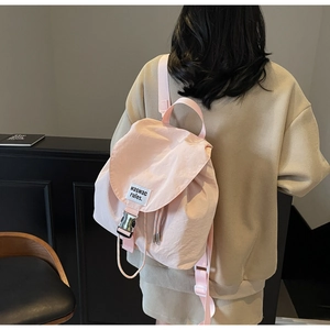 Rear view of a pink canvas backpack for women showing flap cover with metal buckle