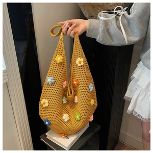 Detail of handmade yellow crochet tote bag with colorful 3D floral embroidery