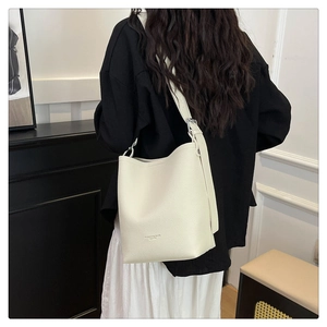 Close-up of off-white pebble leather bucket bag with silver hardware and fashion text