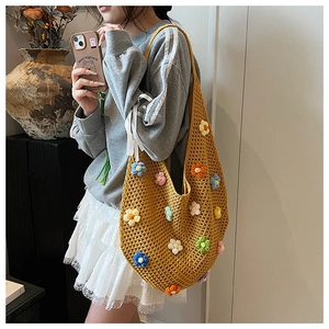 Close-up of yellow handmade crochet shoulder bag with colorful 3D floral appliques