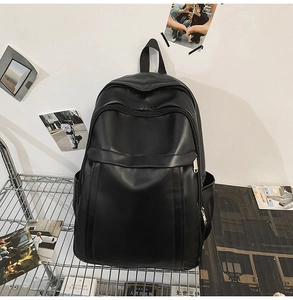 Close-up of minimalist black leather backpack showing premium texture and multi-layer zippers