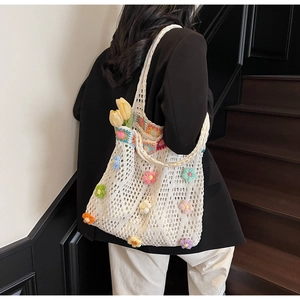 Dettaglio borsa tote all'uncinetto fatta a mano con fiori 3D colorati e trama a rete