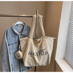Detailansicht einer beige Segeltuchtasche mit kleiner abnehmbarer Geldbörse am Metallbügel