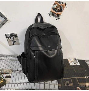 Close-up of black PU leather backpack showing parallel zippers and smooth matte texture