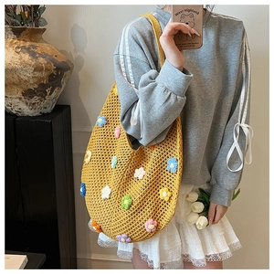 Detailed close-up of handmade yellow crochet tote bag with colorful 3D floral embroidery