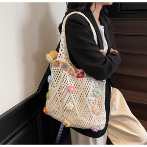 Dettaglio della borsa tote in crochet bianca con fiori 3D colorati e manico
