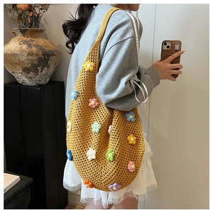 Side view of ginger yellow handmade crochet tote with 3D floral accents on model
