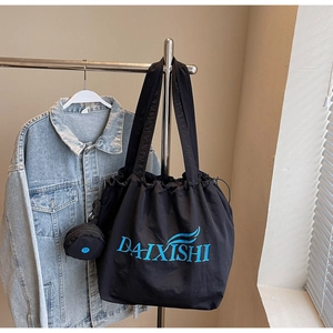 Detail der schwarzen Nylon-Tragetasche mit blauem DAIXISHI-Logo und kleiner Seitentasche