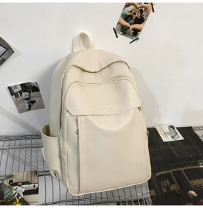 Detail view of a cream minimalist laptop backpack featuring smooth faux leather material