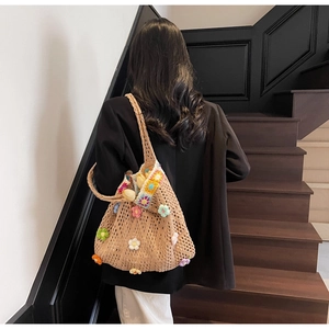 Dettaglio della borsa tote all'uncinetto con fiori 3D colorati e bordo ondulato arcobaleno