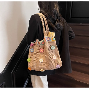 Borsa tote in maglia con fiori all'uncinetto 3D e bordo floreale su una modella