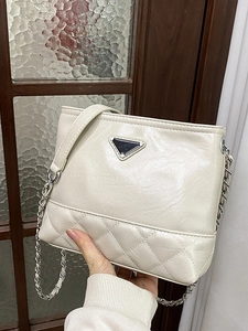 Chic beige bucket bag with diamond quilting, metal chain strap, and triangle emblem