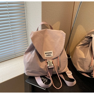 Detail of mauve canvas backpack featuring silver buckles and waswac rules woven label