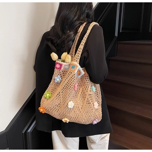 Borsa tote in maglia con fiori all'uncinetto colorati sulla spalla della modella