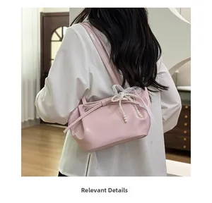Vue détaillée du sac à bandoulière plissé rose avec perle et nœud décoratif