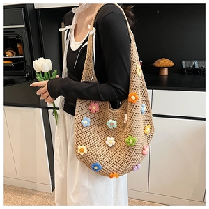 Detail of colorful hand-crocheted floral accents on a beige woven tote bag for summer