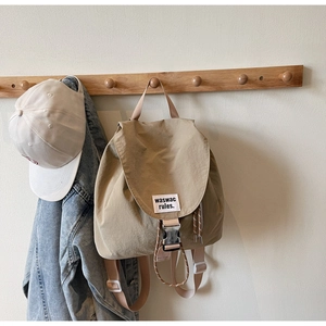 Detail of khaki canvas backpack with buckle closure and stylish woven logo label