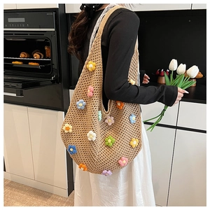 Detail of handmade crochet tote bag with colorful 3D flower knit pattern and wide strap