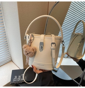 Détail du sac seau crème texture lychee avec fermoir métal et breloque ourson