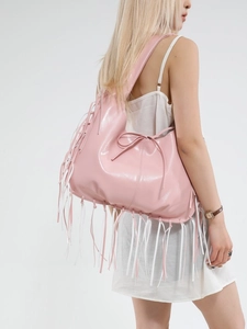 Grote roze shopper met franjes van glanzend materiaal gedragen door een vrouwelijk model