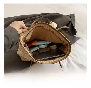 Vue détaillée du sac cabas en paille montrant la grande capacité et la fermeture