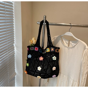 Dettaglio della borsa tote in crochet nero fatta a mano con fiori 3D colorati e maglia