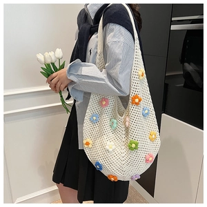 Detail of colorful handmade crochet tote bag with 3D flowers and spacious knit design