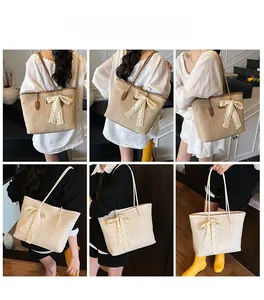 Sac cabas en paille avec nœud en dentelle porté par un mannequin en marron et beige