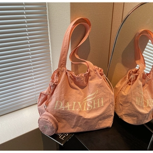 Detail der rosa Nylon-Tragetasche mit Knitteroptik und kleiner runder Münztasche