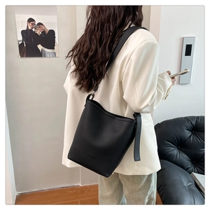 Detail showing the textured black leather bucket bag back view with long shoulder strap