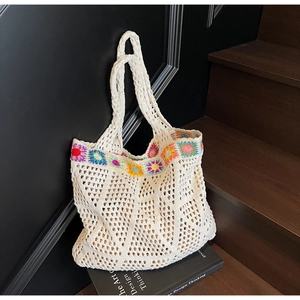 Dettaglio della borsa tote all'uncinetto con ricami floreali e design traforato