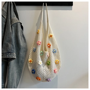 Detailed close-up of colorful crochet flowers on a white handmade woven tote bag