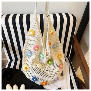 Detail of white handmade crochet tote bag featuring vibrant 3D knit floral patterns