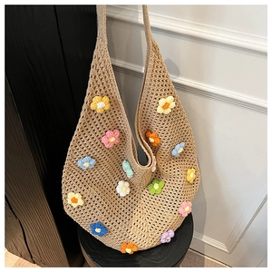 Detail of handmade crochet tote bag featuring multi-colored 3D flowers and hollow weave