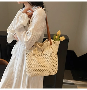 Dettaglio della borsa tote intrecciata a mano con trama traforata e tracolla in pelle