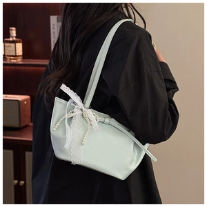 Détail du sac seau vert menthe plissé avec nœud en dentelle blanche et perles