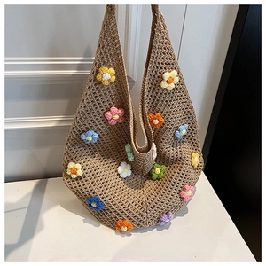 Macro detail of hand-woven straw tote with colorful 3D crochet flower embellishments