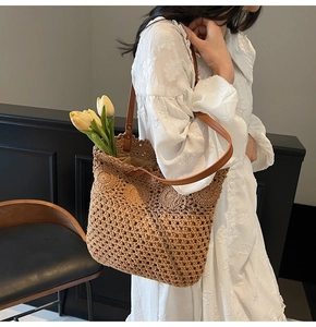 Dettaglio della borsa crochet tessuta a mano con manici in pelle su abito in pizzo