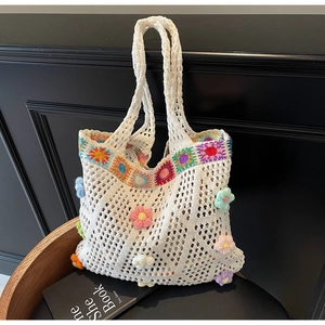 Dettaglio ravvicinato della borsa tote all'uncinetto con fiori 3D colorati applicati